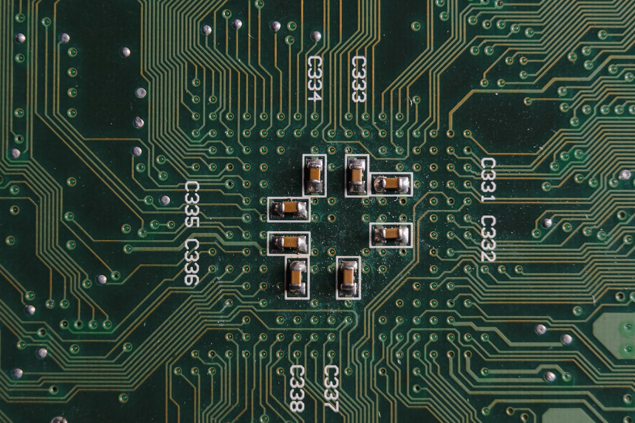 Explore the intricate design and components on a green circuit board with capacitors and pathways.